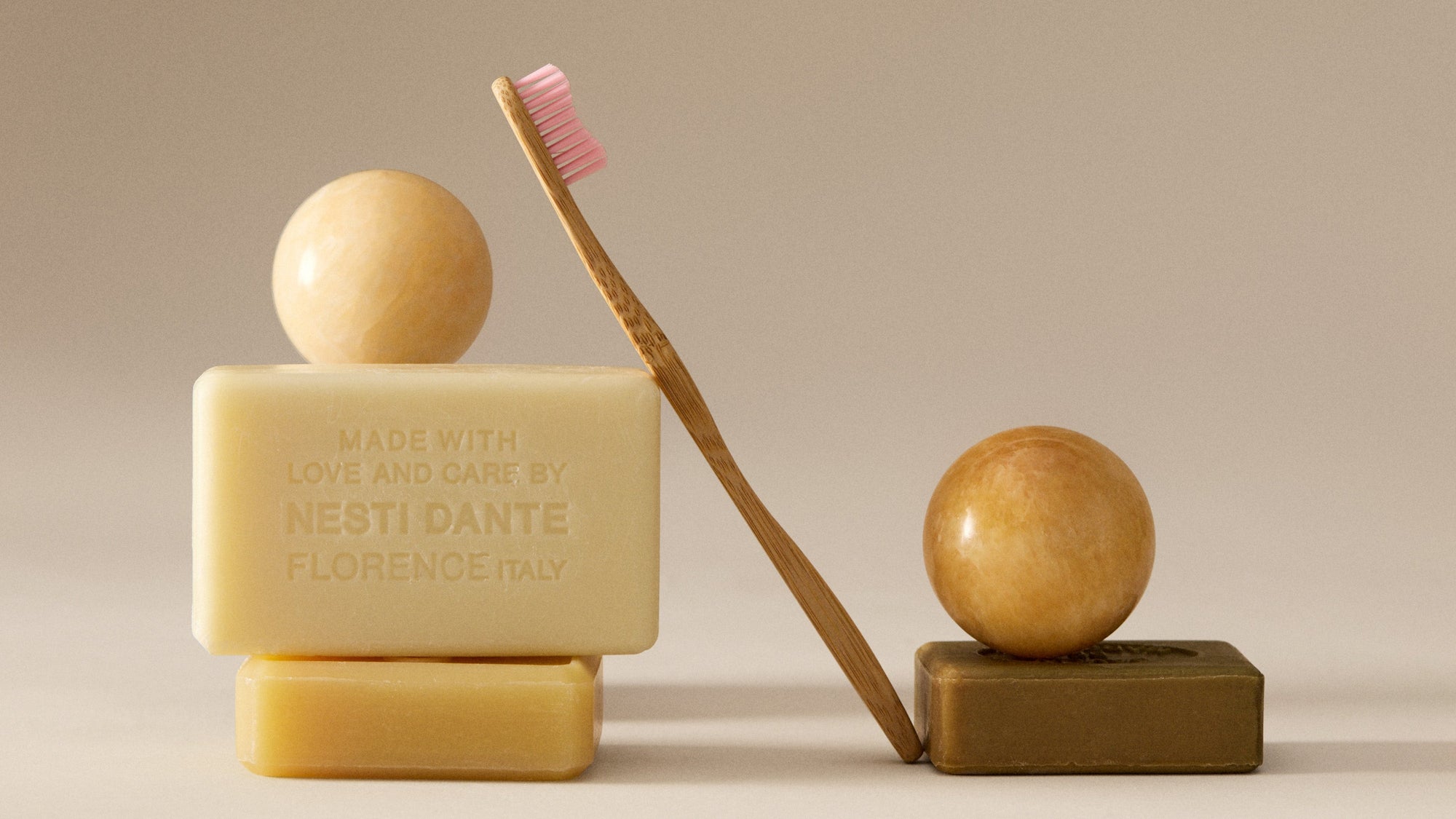 Bar of soap, brush, and wooden block on a neutral background