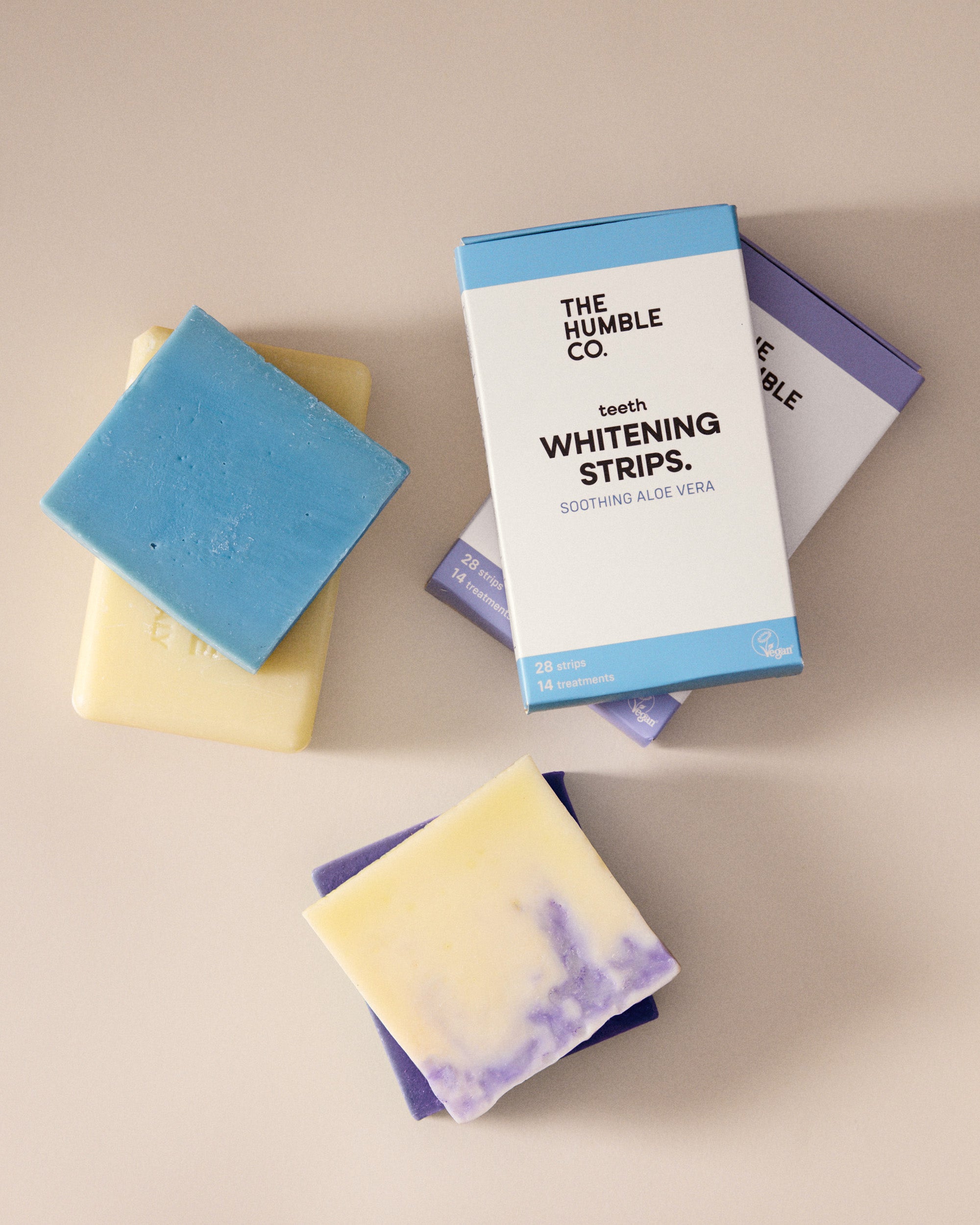 The Humble Co. teeth whitening strips packaging with two soap bars on a beige background