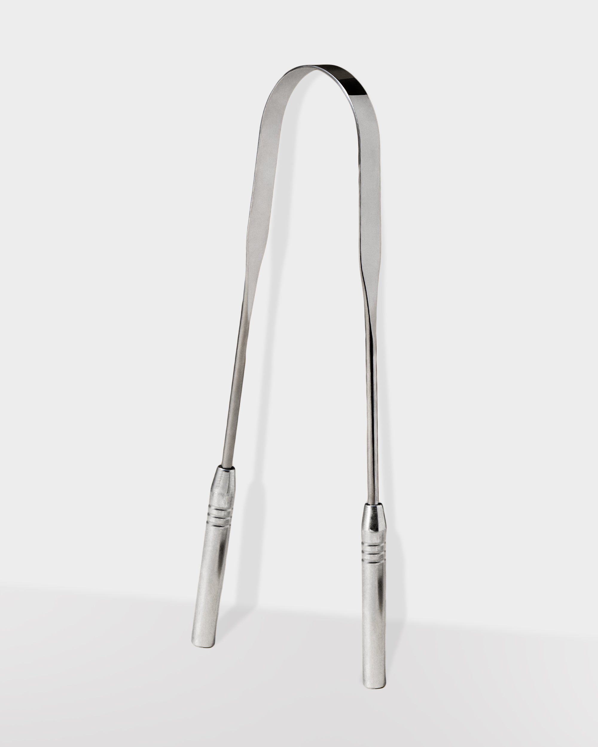 A silver stainless steel tongue scraper with a curved shape and ribbed handle.