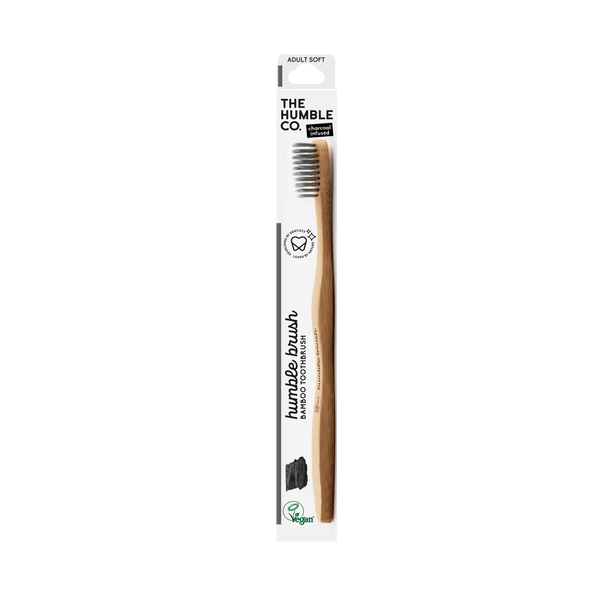 A bamboo toothbrush with soft charcoal-infused bristles from The Humble Co., promoting a sustainable and effective oral hygiene routine.
