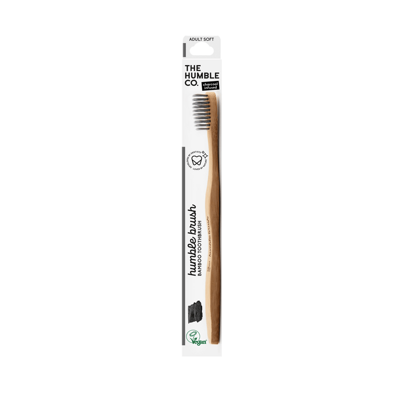 A bamboo toothbrush with soft charcoal-infused bristles from The Humble Co., promoting a sustainable and effective oral hygiene routine.