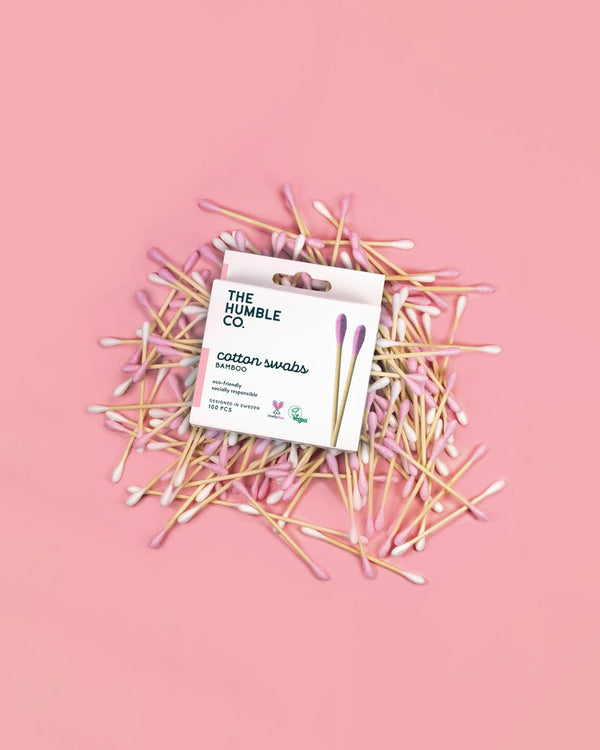 Pink cotton swabs stacked in a neat arrangement on a pink background, creating a vibrant pink display.