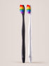 Two toothbrushes with rainbow bristle heads on a beige background