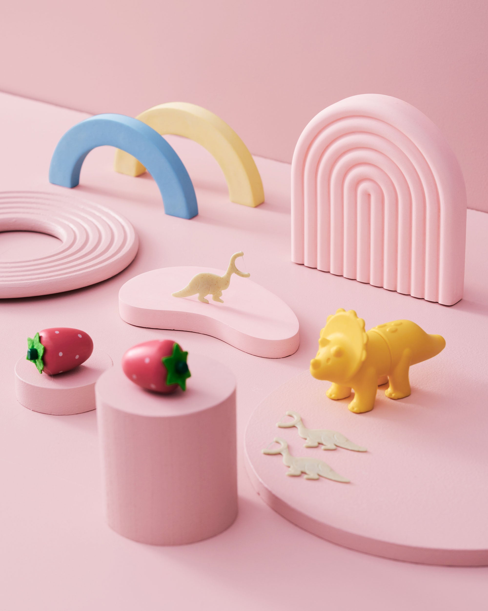 Pastel-colored geometric toys on a pink background and the humble co kids floss picks