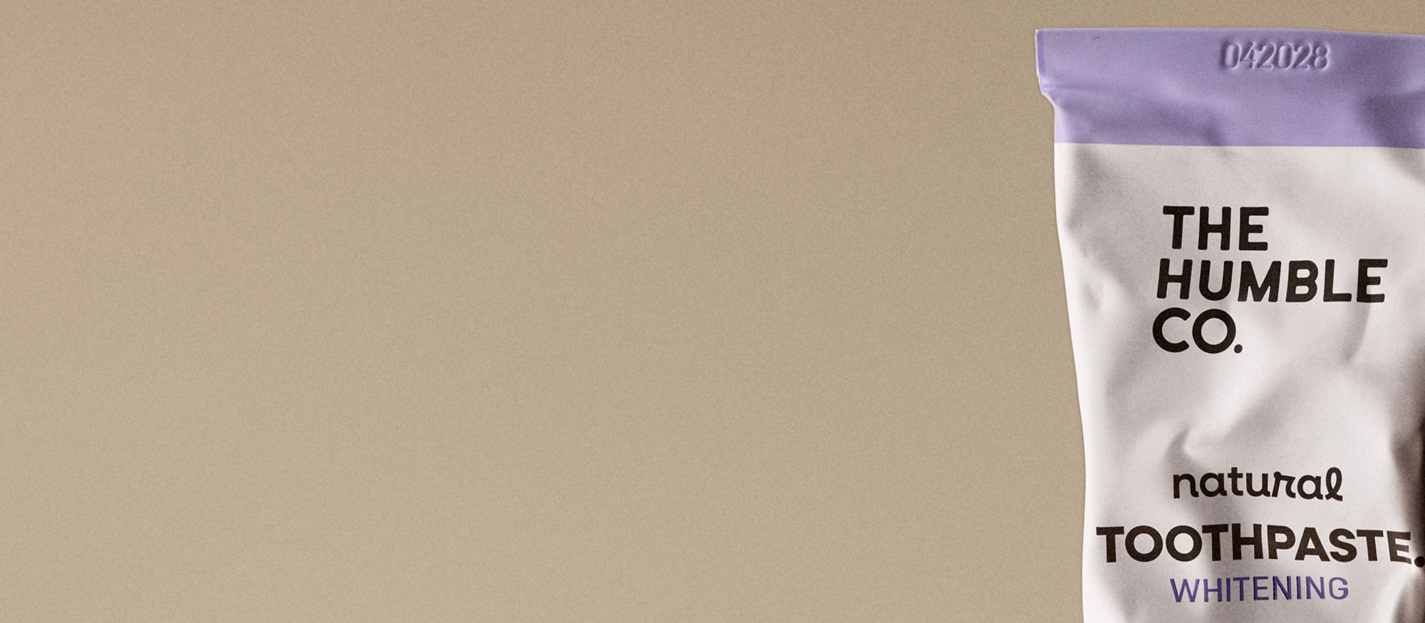 The Humble Co. natural toothpaste packaging on a beige background