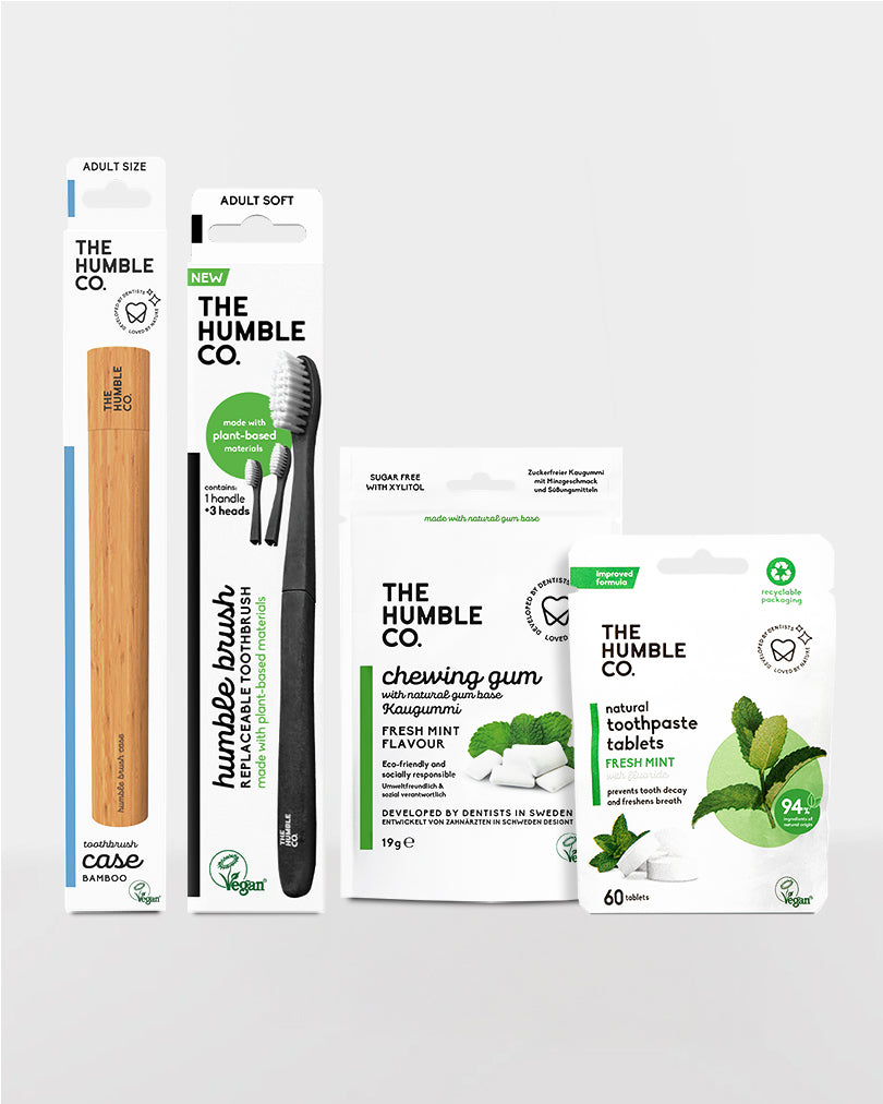 Collection of The Humble Co. dental care products including a toothbrush, toothpaste tablets, and chewing gum on a white background.