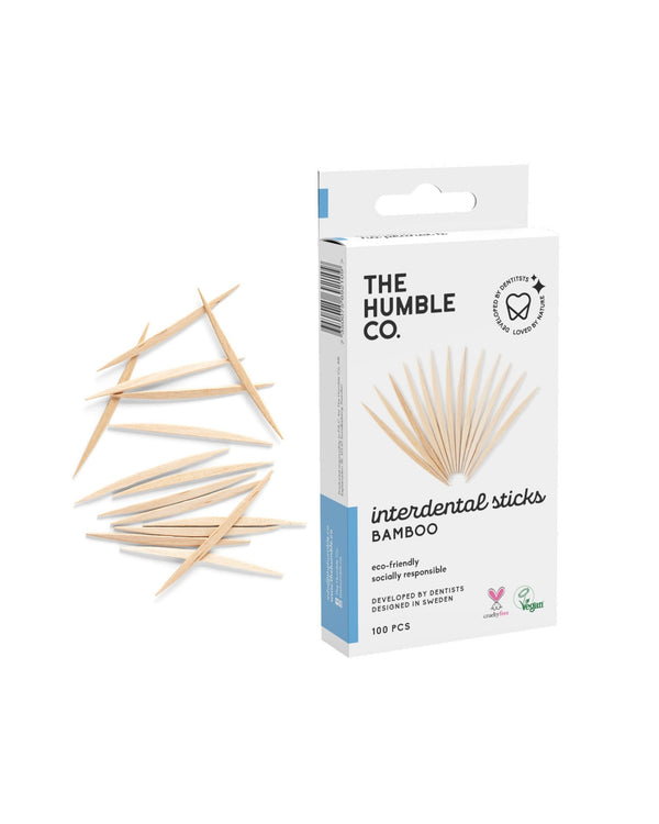 A box of The Humble Co. bamboo toothpicks with a pile of toothpicks beside it, designed with sustainable and eco-friendly materials to promote good oral hygiene.