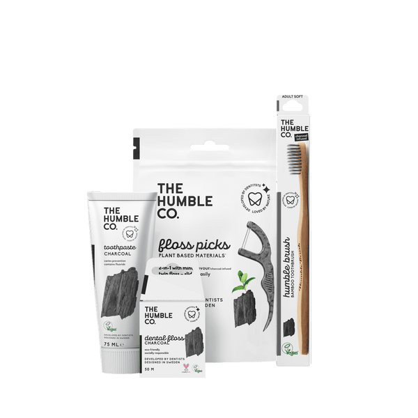 A sustainable oral care set from The Humble Co., featuring charcoal toothpaste, bamboo toothbrush, and floss picks, promoting eco-friendly and effective oral hygiene.