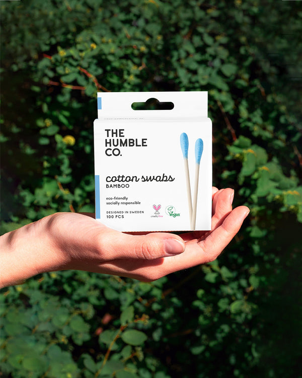 A person holds a box of The Humble Co. Bamboo Cotton Swabs, a sustainable option for reducing plastic waste.