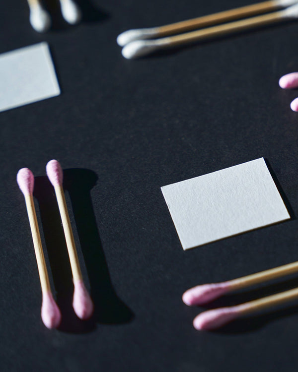A black background with a group of pink cotton swabs.